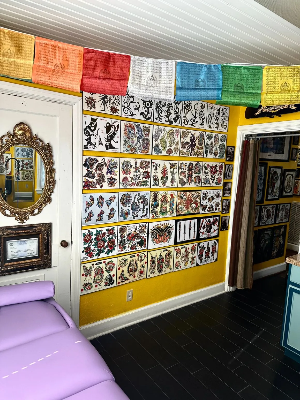 Tattoo station beneath a wall of traditional flash